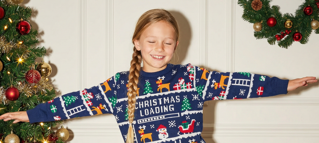 Lächelndes Mädchen mit Zopf trägt bunten Weihnachtspullover mit Christmas Loading Schriftzug